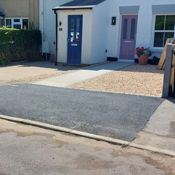 A newly laid natural stone driveway in front of a house, complete with convenient dropped kerbs for easy access.